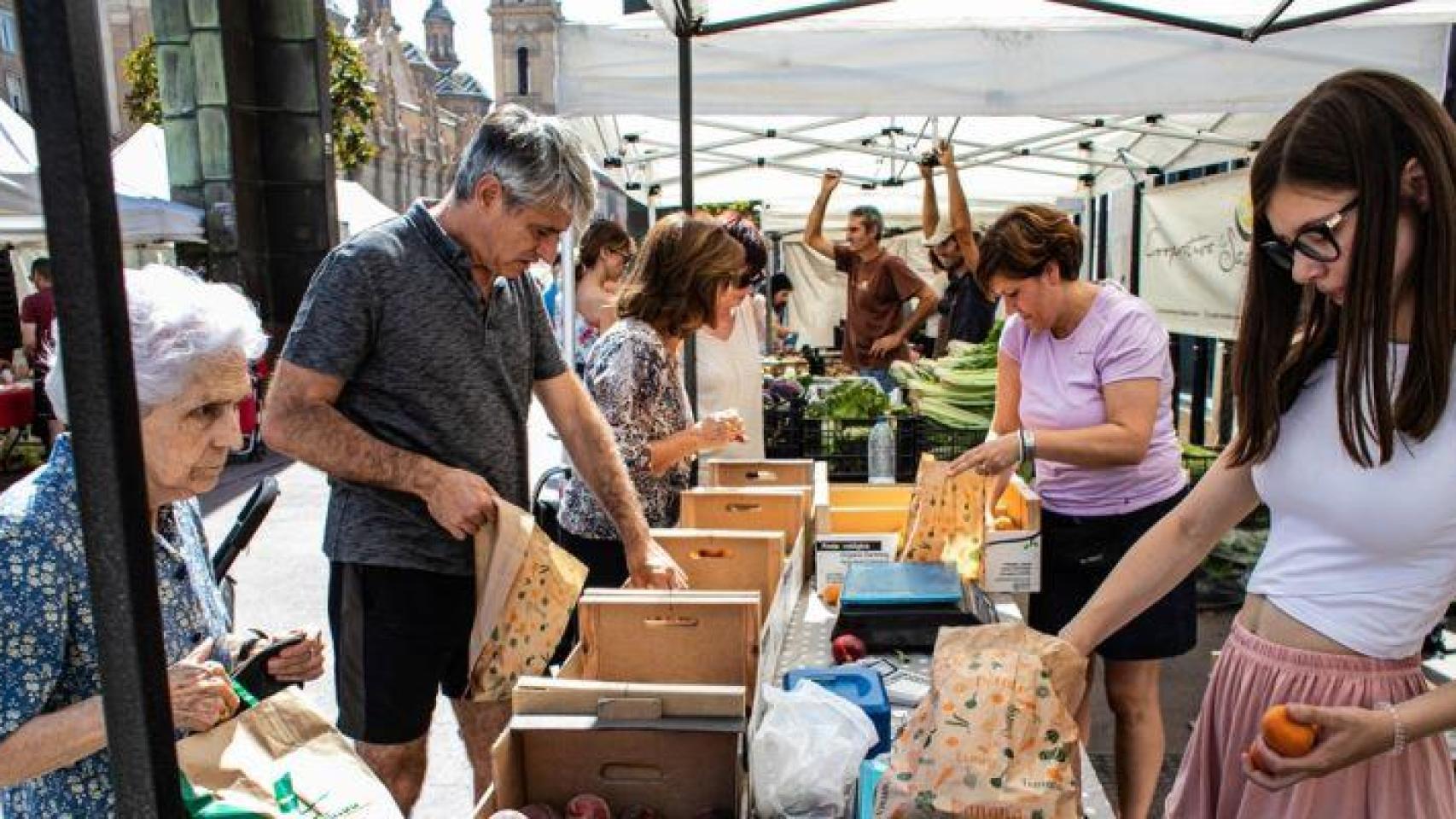 Varias personas haciendo la compra en un mercado agroecológico.