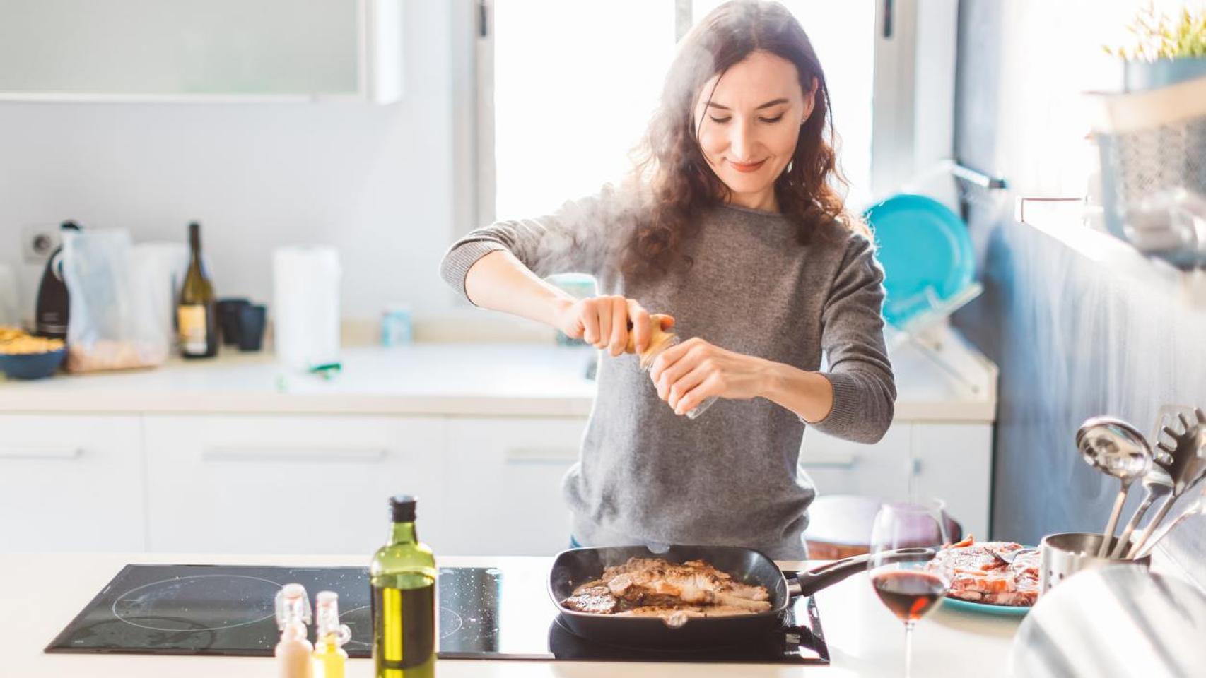 Mujer cocinando carne.