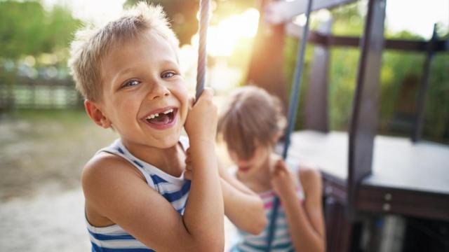 Unos niños riendo y jugando en un parque.