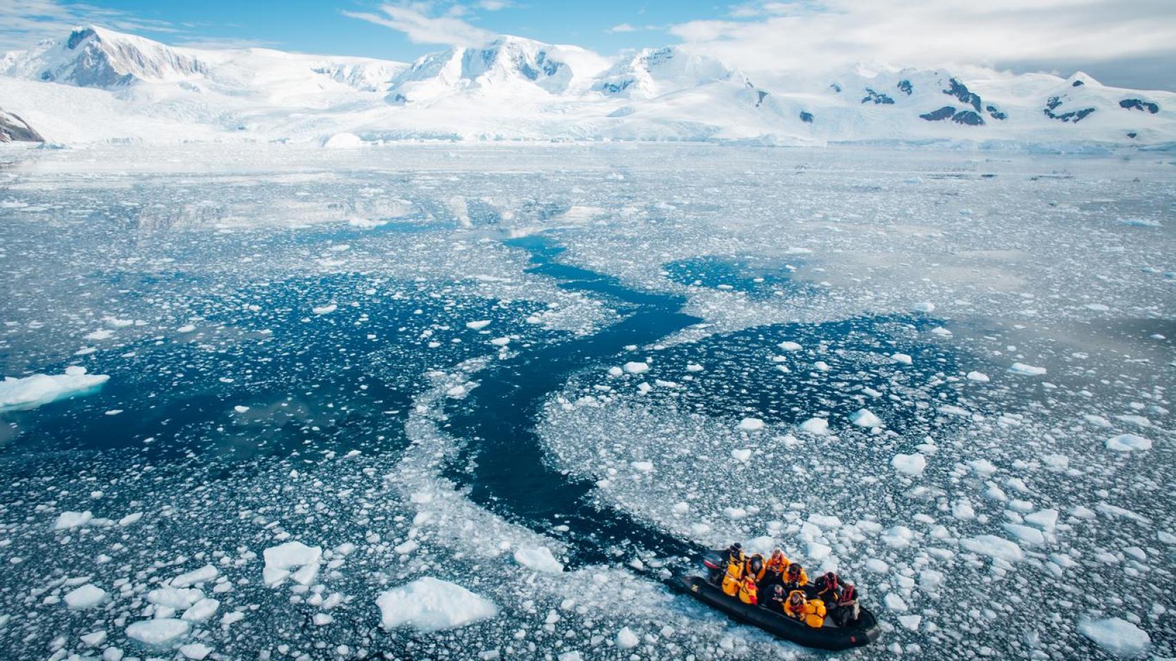 Equipo de exploradores que regresa de la Península Antártica en un bote Zodiac.