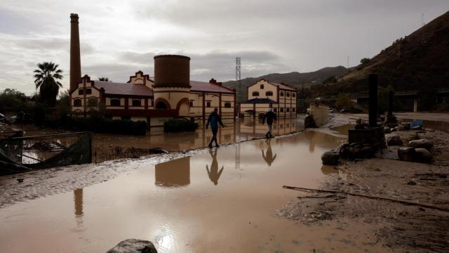 Un hombre en una zona anegada por el agua en Álora.