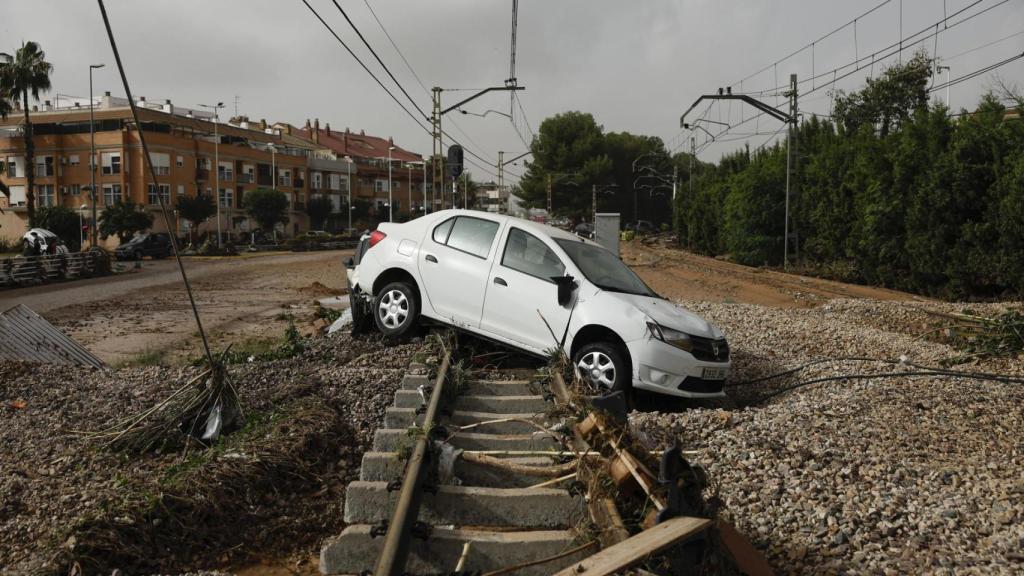 La fuerza del agua ha arrastrado un coche hasta las vías del tren en Picaña (Valencia).