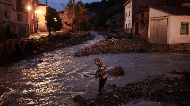 Miguel, de 69 años, lava sus escobas en el Río Seco después de limpiar su casa, en medio de las inundaciones provocadas por las fuertes lluvias, en La Hoz de la Vieja, provincia de Teruel, España.