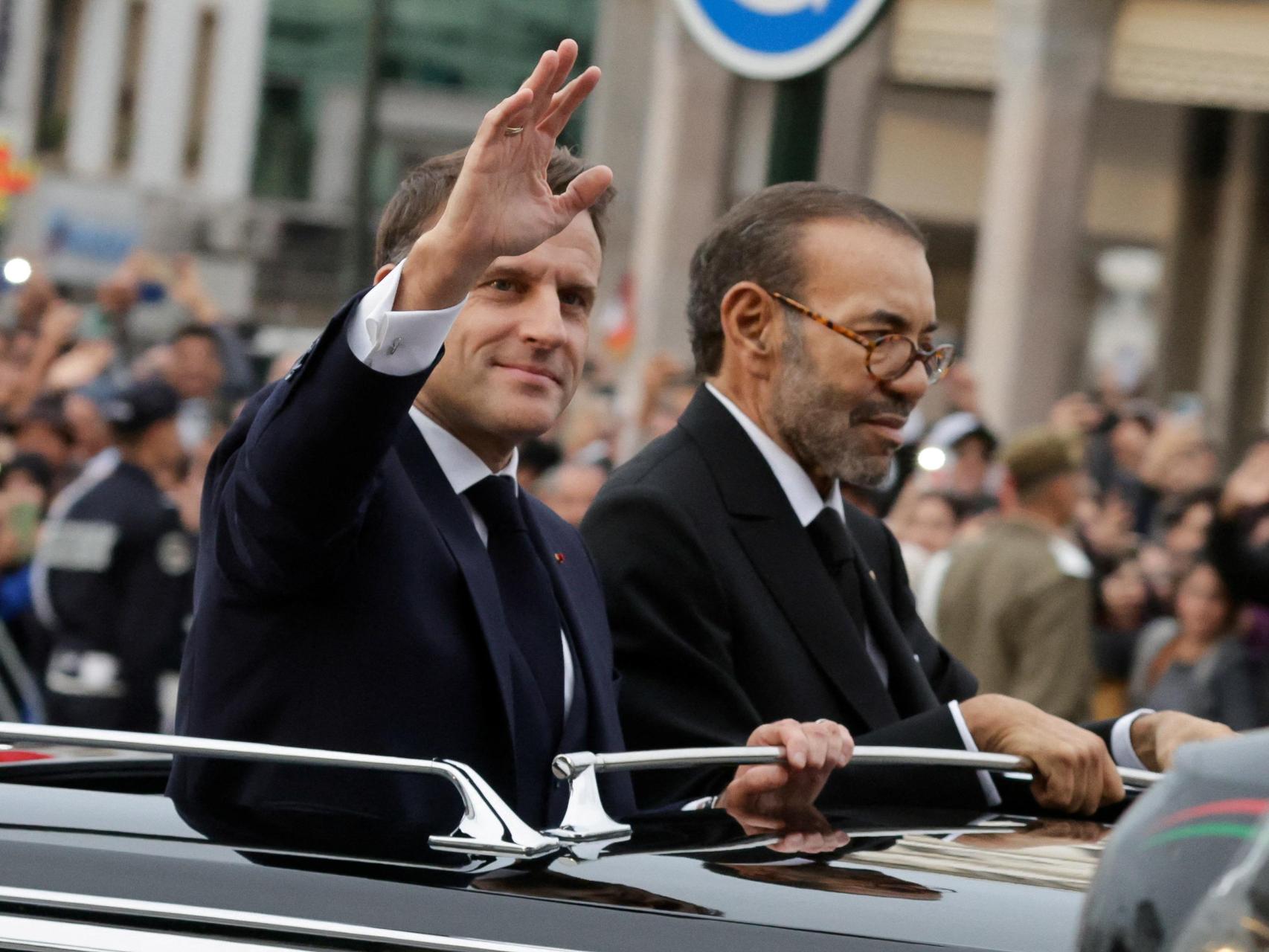 El presidente francés, Emmanuel Macron, saluda a la multitud durante su gira con el rey de Marruecos.