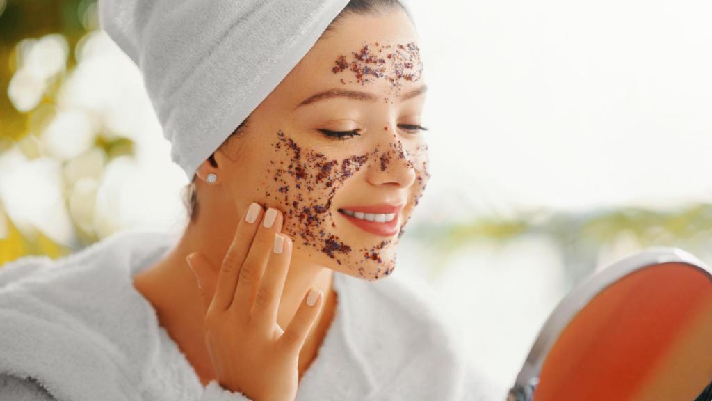 Mujer exfoliándose el rostro.