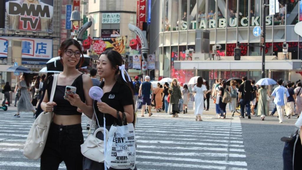 Dos jóvenes cruzan una calle en Tokio.