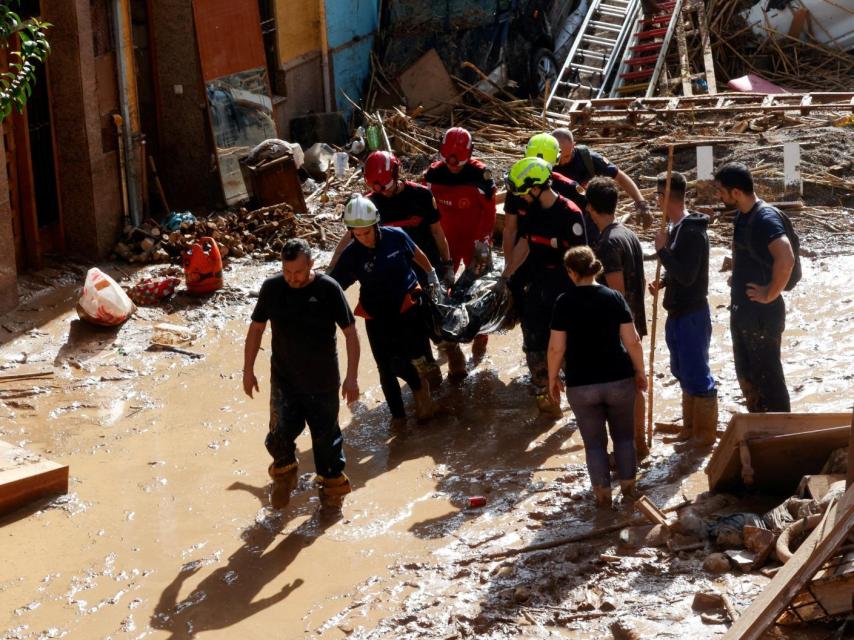 Bomberos sacan un cadáver de los escombros producidos por la DANA en Valencia.