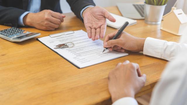 Dos personas en la firma de un contrato, en una imagen de Shutterstock.