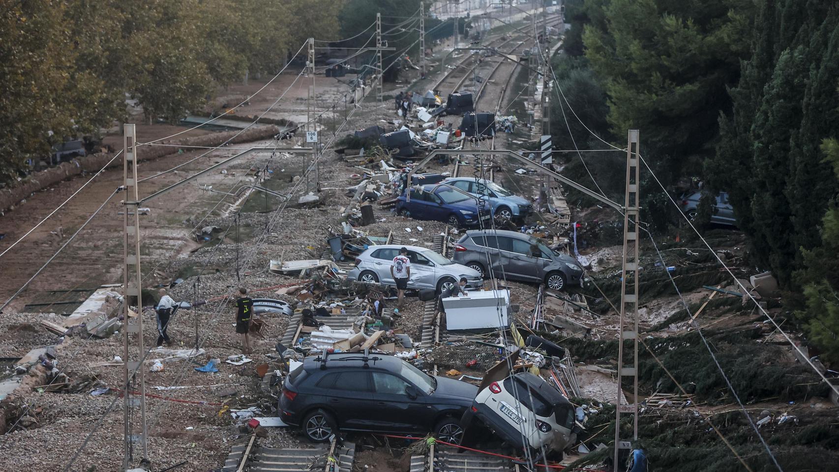 Varios coches sobre las vías de tren en Alfafar, en Valencia, tras el paso de la DANA.