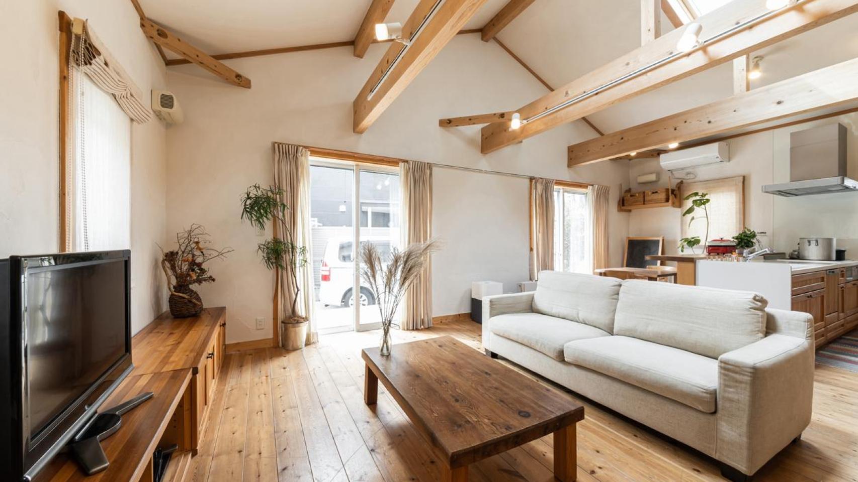 Salón de una casa con interior de madera y amplios ventanales.