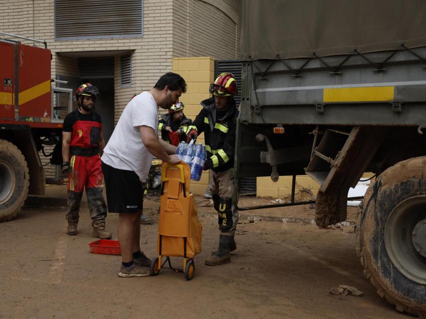 Efectivos de la UME reparten agua a los vecinos de Paiporta.