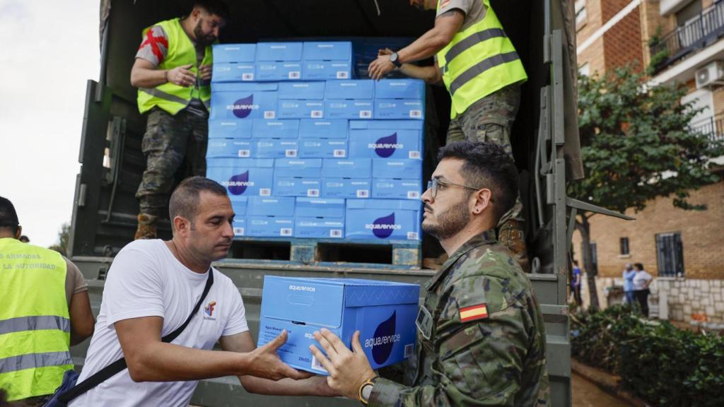 Vecinos de Paiporta reciben agua repartida por el Ejército este viernes