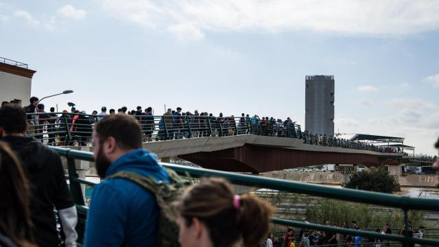 Miles de personas cruzando el puente que une Valencia y Paiporta cargados de agua, comida y utensilios de limpieza.