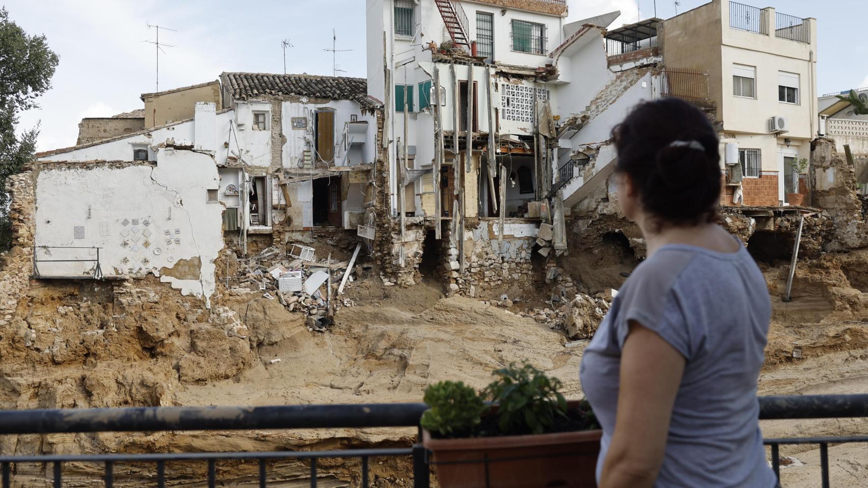 Una mujer observa varias casas dañadas en Chiva, provincia de Valencia, tras el paso de la DANA.