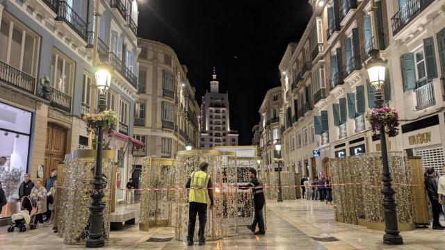 Imágenes de los operarios trabajando en la iluminación navideña de calle Larios.