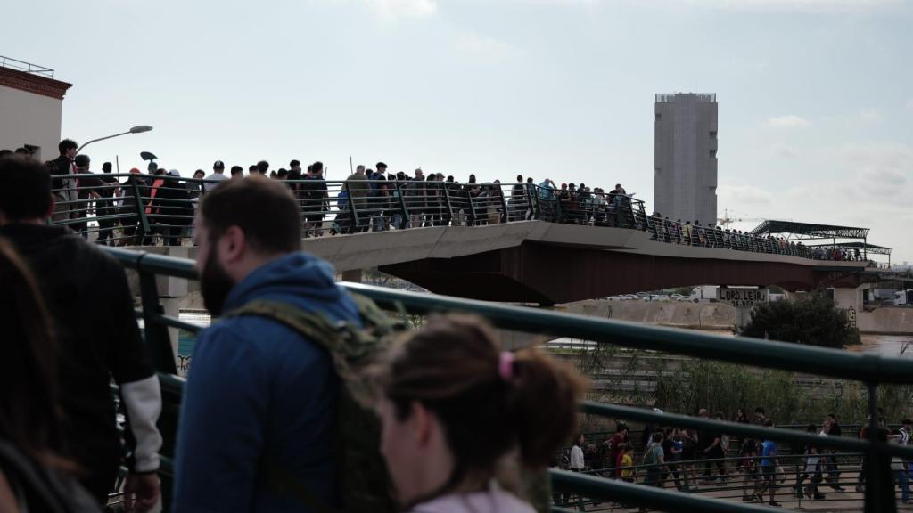 Miles de personas cruzando el puente que une Valencia y Paiporta cargados de agua, comida y utensilios de limpieza.