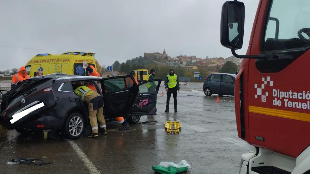 Los bomberos de la Diputación Provincial de Teruel sacando a las dos personas atrapadas en el vehículo.