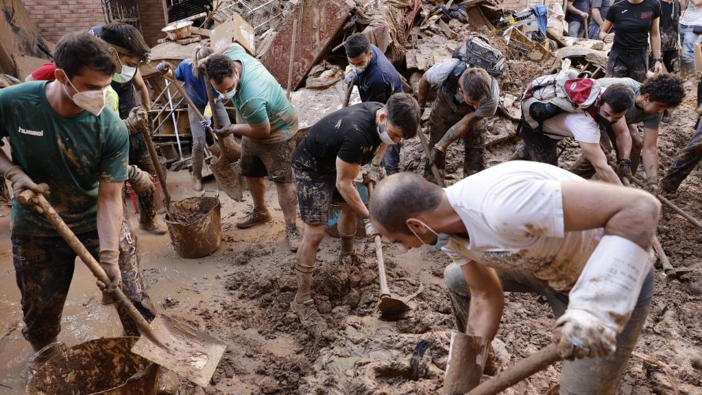 Un grupo de hombres retira lodo de Utiel (Valencia) para hacer frente al desastre natural causado por la DANA en la región.