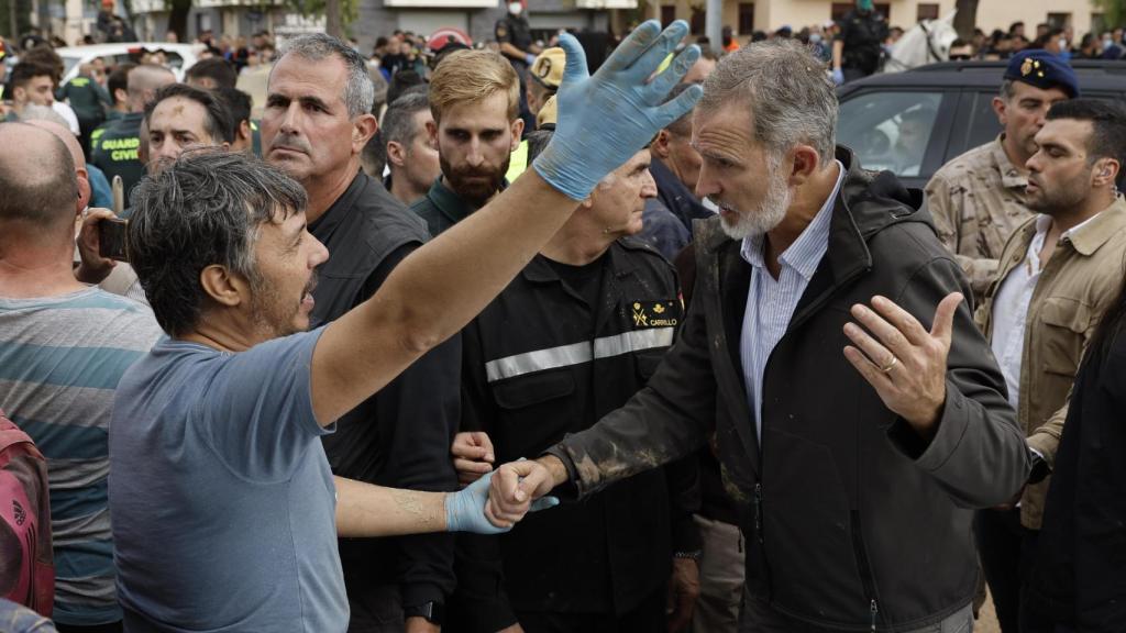 El rey Felipe habla con un afectado por la riada, durante su visita a Paiporta este domingo.