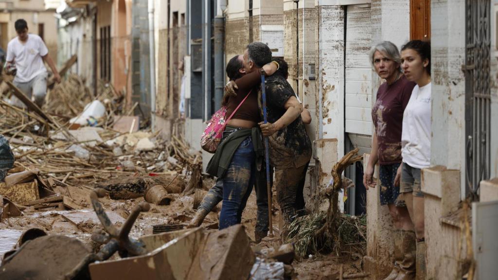 Dos personas se abrazan en medio de la tragedia de la DANA en Valencia. Efe / Biel Aliño