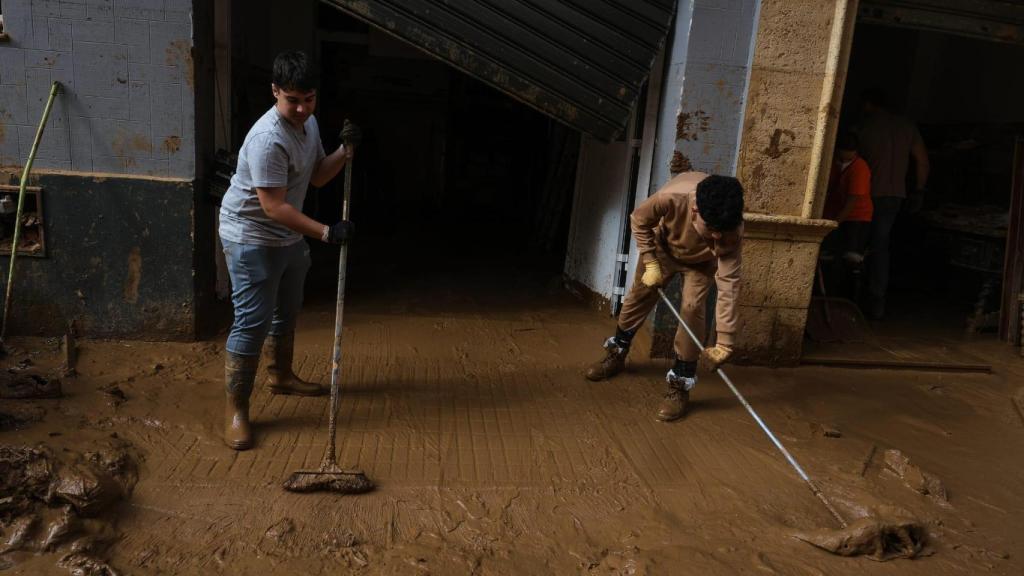 Niños ayudando a sacar los escombros de las casas y locales en Paiporta.