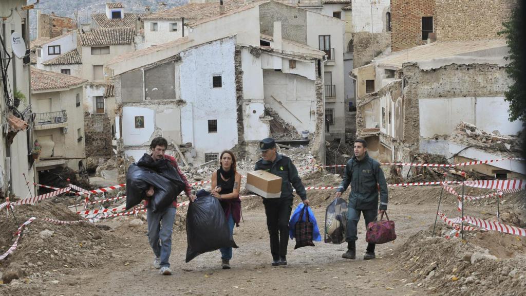 Dos vecinos de Letur, acompañados por la Guardia Civil, recogen enseres de sus casas destrozadas.