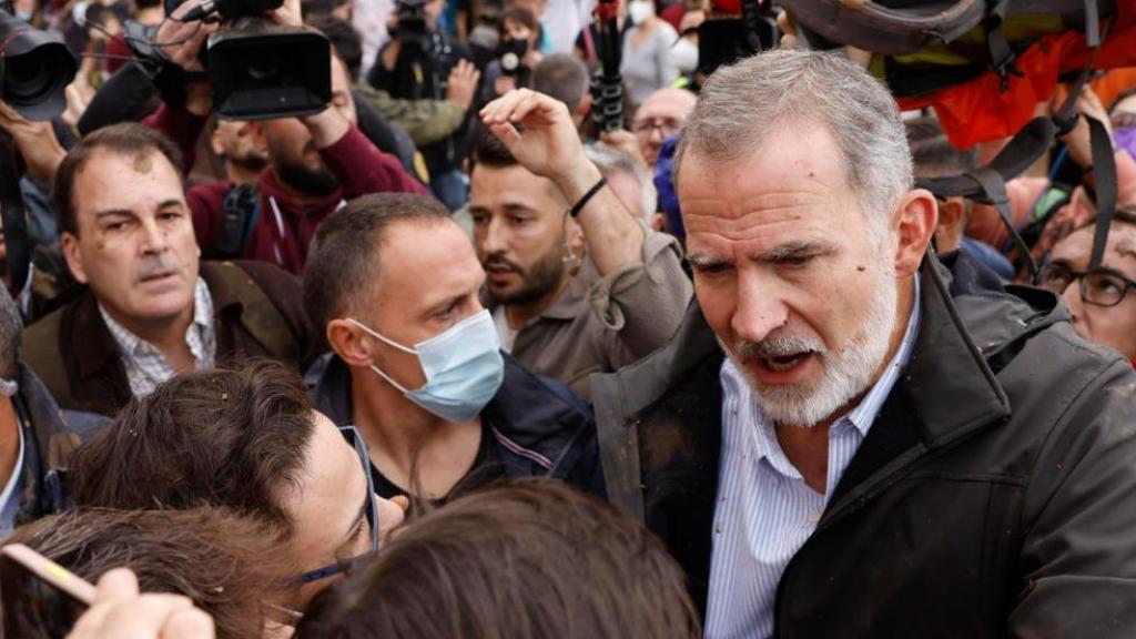 Felipe VI con vecinos de Paiporta, el domingo, seguido de cerca por el jefe de Seguridad de la Casa Real, Miguel Herráiz, a la izquierda de la imagen, sin mascarilla.