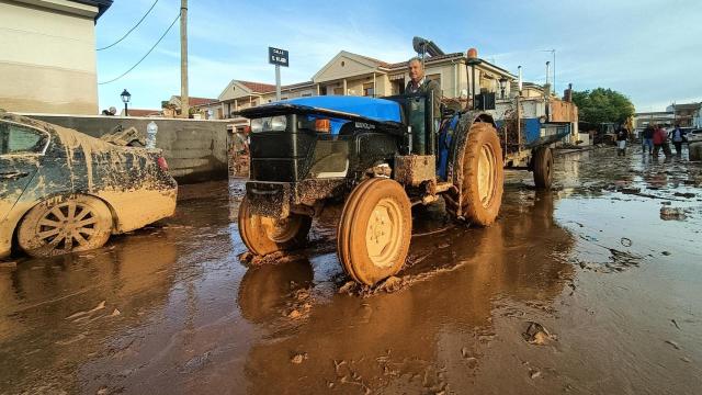 Un hombre con su tractor colabora en la limpieza de las calles en Utiel, Valencia.