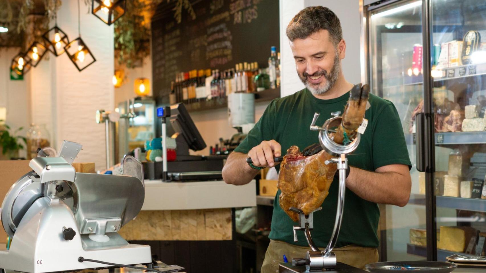 El dueño de Gaia Espacio Gastronómico, Raúl Rodríguez, corta jamón en su restaurante.