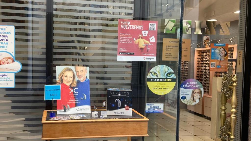 Imagen del cartel de Volveremos en la puerta de un comercio de Zaragoza.