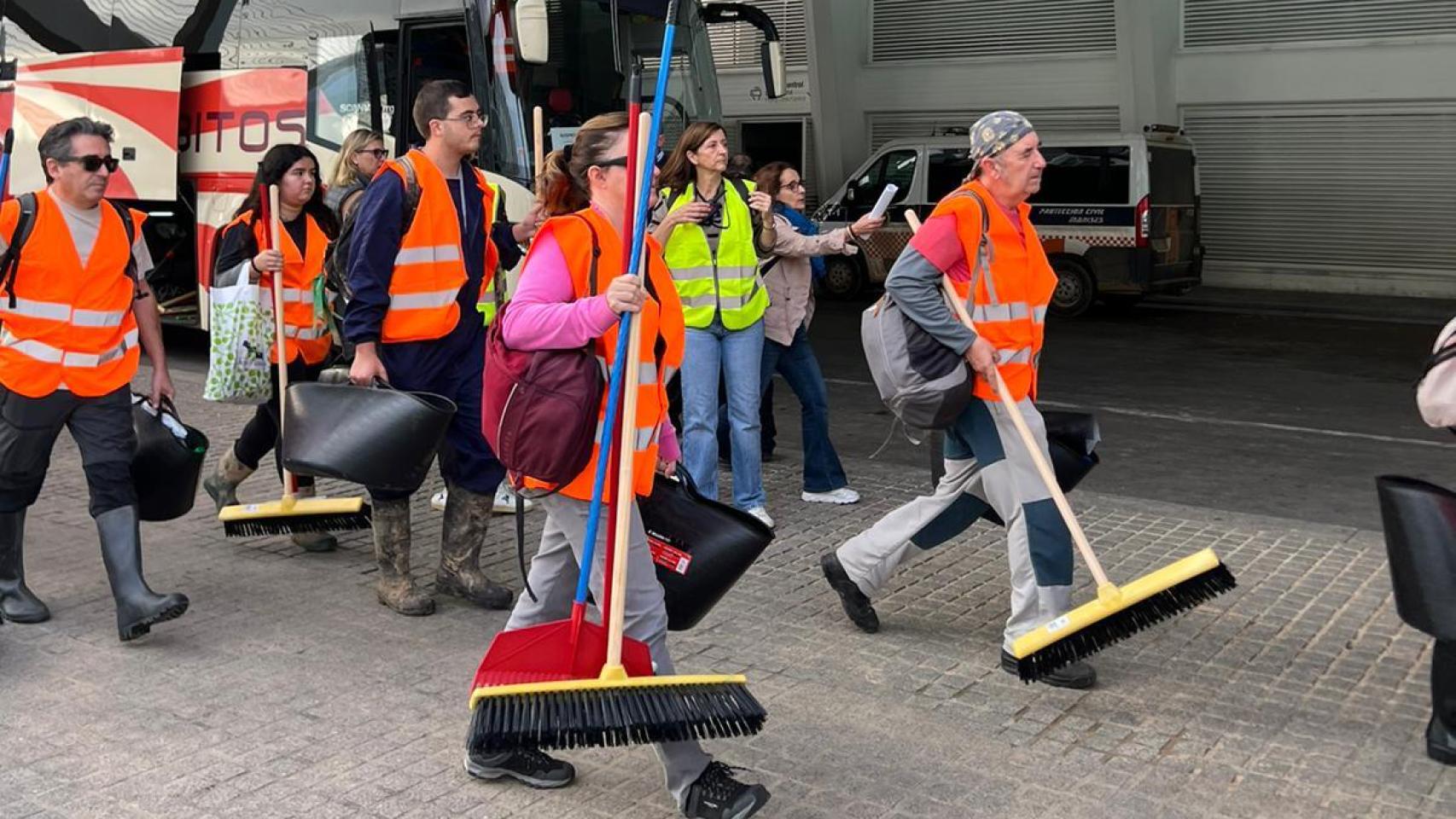 Algunos de los voluntarios acuden a los autobuses.