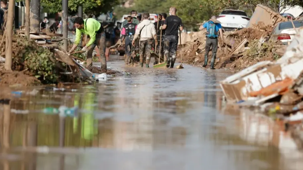 Voluntarios y vecinos trabajan para despejar una calle de Paiporta (Valencia).