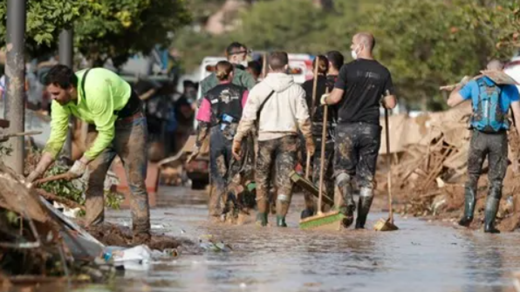 Voluntarios y vecinos trabajan para despejar una calle de Paiporta (Valencia).