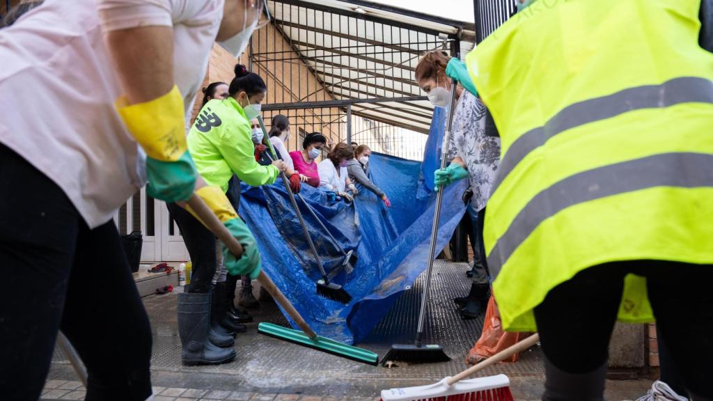 Un grupo de voluntarias achican agua de un centro próximo al CEIP Castellar-Oliveral.