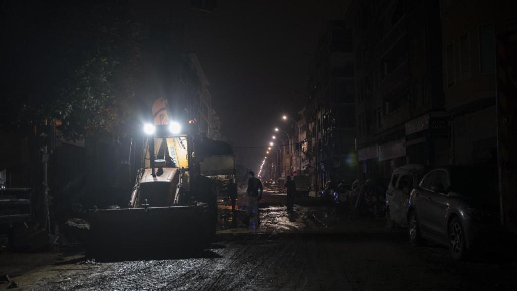 Equipos de limpieza retirando escombros en Catarroja (Valencia) de madrugada.