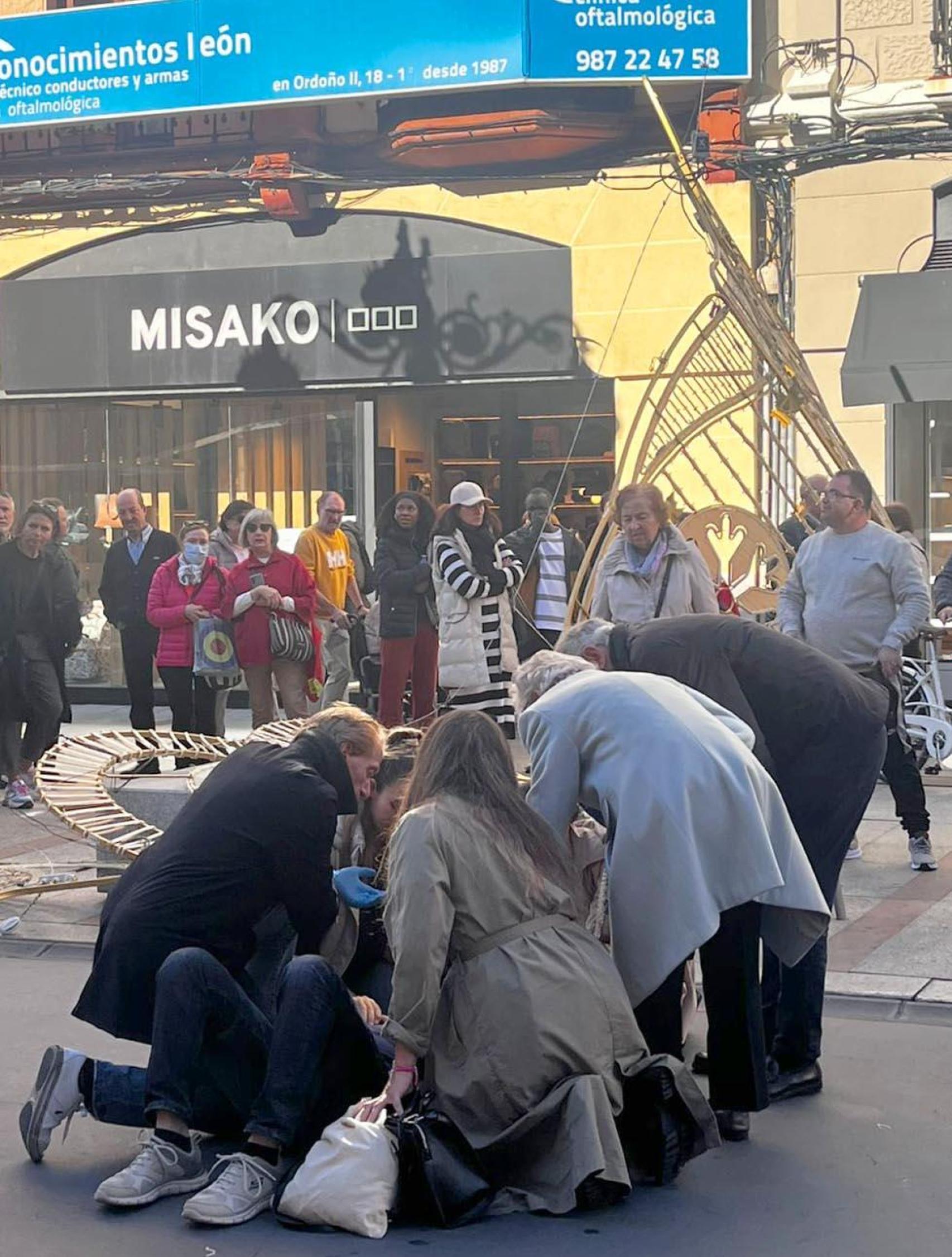 Viandantes atendiendo al herido en el centro de León