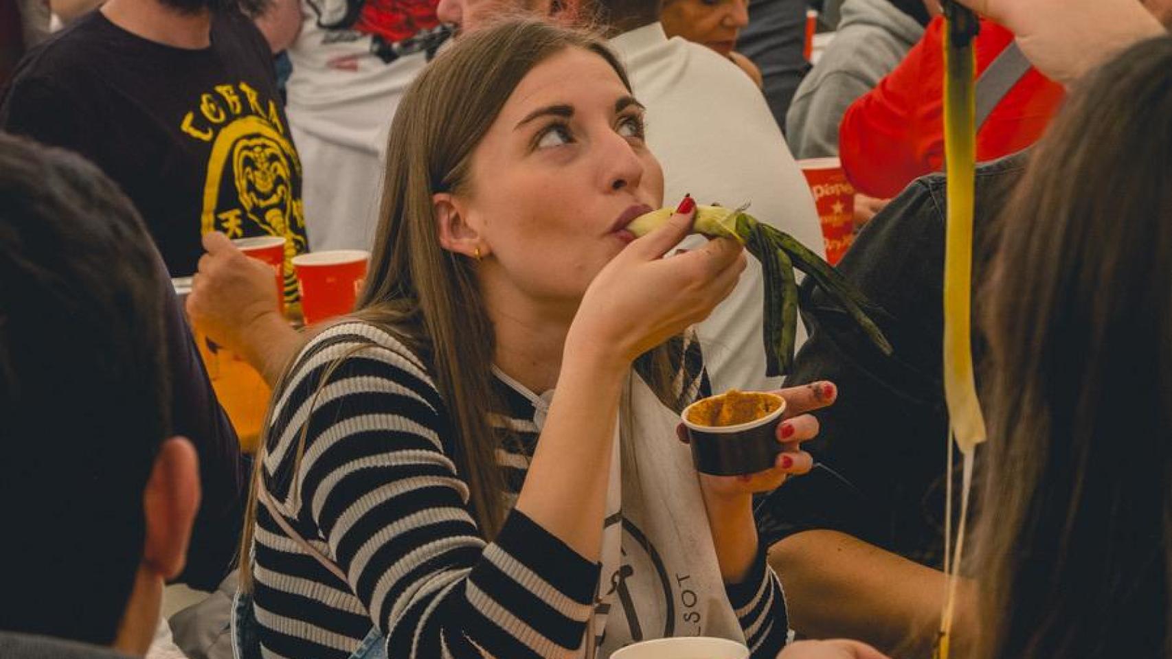 Una chica disfrutando de unos calçots.