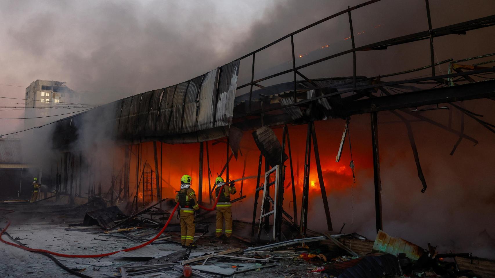 Los bomberos trabajan en el recinto de un almacén de verduras atacado por un dron ruso en Kiev.