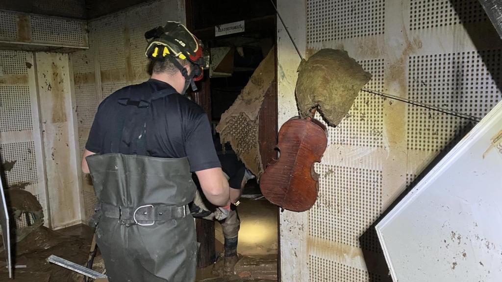 Un bombero accede a la sede de la Societat Musical d'Algemesí, devastada por la DANA. EE