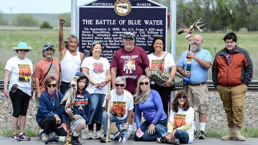 Un grupo de escursionistas en Nebraska, ante un cartel histórico del Blue Water.