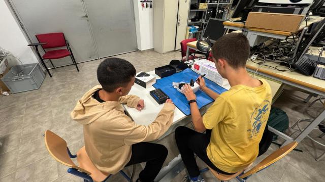 Dos jóvenes arreglando unas gafas de realidad virtual en un centro educativo de Málaga.