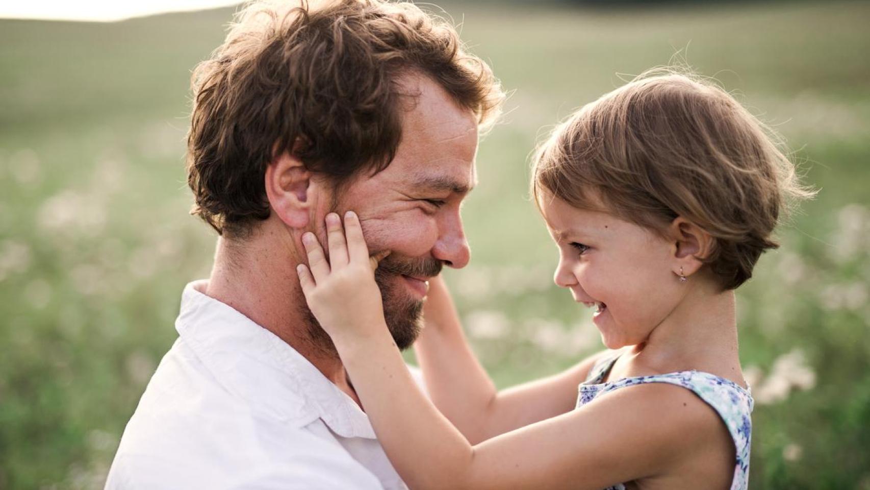 Padre junto a su hija pequeña en la naturaleza.