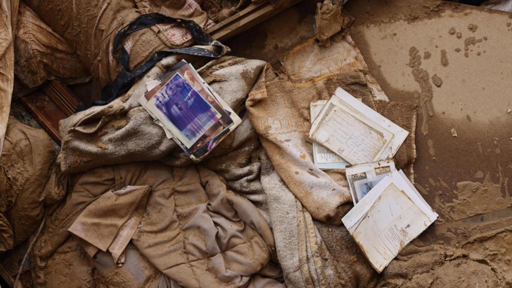 Fotografías y documentos personales cubiertos por el lodo en Sedaví, Valencia. Efe / Ana Escobar