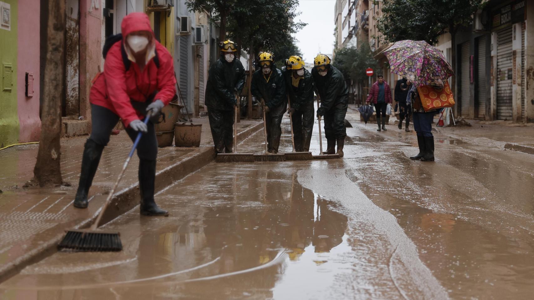 Un grupo de bomberos de Málaga trabaja en la limpieza de calles en Catarroja este miércoles.