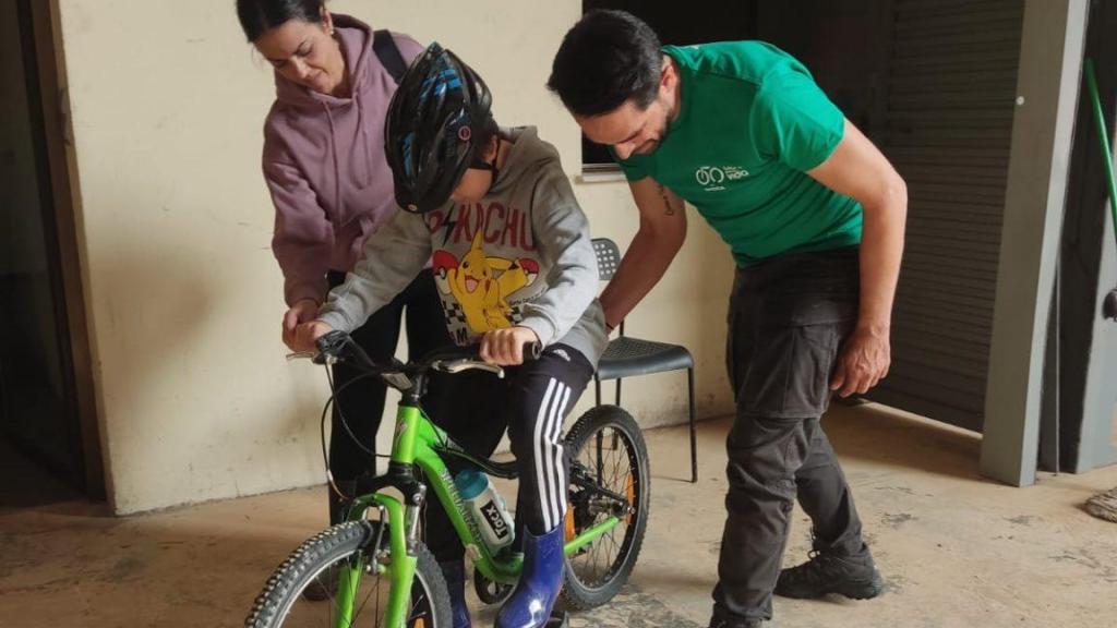 Alberto Contador entrega una de las bicicletas a un niño.