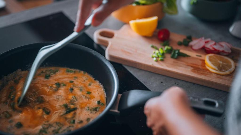 Persona cocinando en una sartén.