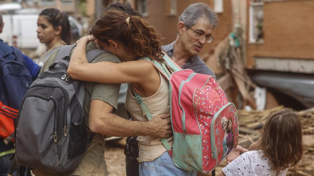 Dos personas se abrazan en una calle de Paiporta (Valencia) arrasada por la DANA del 29 de octubre.