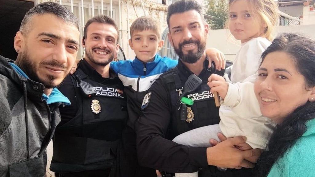 Los dos policías nacionales y la familia a la que rescataron cuando su casa se inundaba en Málaga.