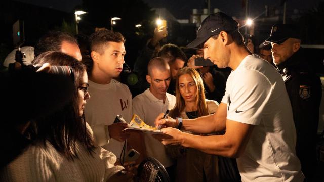 Rafa Nadal firma autógrafos a seguidores en el aeropuerto de Málaga.