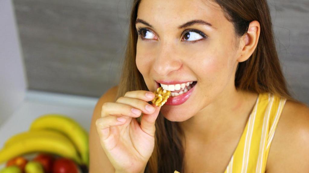 Mujer comiendo nueces.